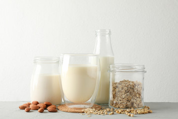 Bootle and glass of different types milk on gray background, space for text
