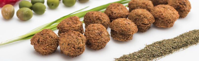 close up view of olives, green onion and falafel on white background, panoramic shot