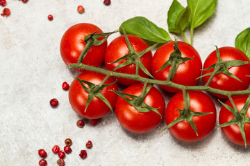 Tomates cherry con hojas de albahaca ingredientes para cocinar sobre un mármol gris Vista superior...
