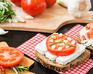 Healthy food. Vegetarian food. Italian bruschetta with White Goat Cheese with Tomatoes, Garlic and Rosemary. Cheese Vegetable Sandwich