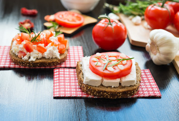 Healthy food. Vegetarian food. Italian bruschetta with White Goat Cheese with Tomatoes, Garlic and Rosemary. Cheese Vegetable Sandwich