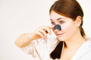 Woman applying pore strips on nose