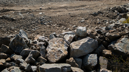 Grunge stone background. Big stones on brown earth.
