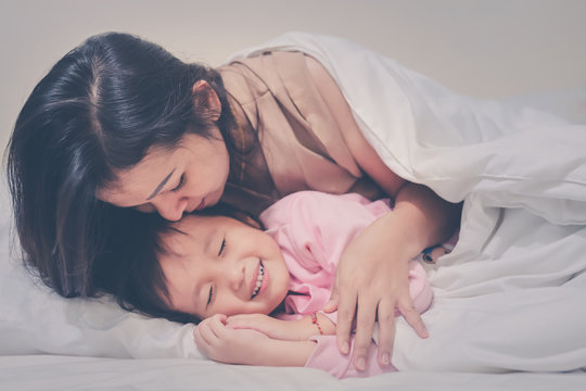 Mother Gently Kissing Daughter Wishing Good Night Sweet Dreams At Night Time Soft Focus Happy Family Warm Tone Filter