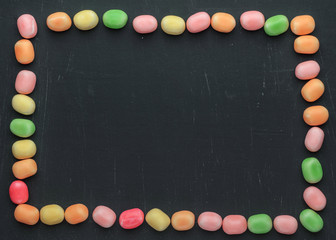 frame of multi-colored candies on a dark background with copy space - 305420286