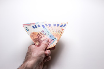 Male hand holds euro banknotes on a white isolated background. Close-up.