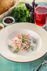 Beef salad with fresh tomatoes, bell pepper and pickles and glass of red drink on blue wooden table