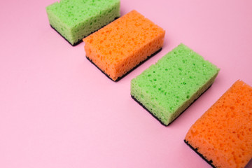 Obraz na płótnie Canvas Sponge for washing dishes on a pink isolated background.