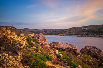 beautiful sunset and seascape view with mountains of Golden Bay, Malta, travel background