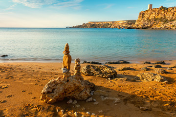 beautiful seascape scene of stones pyramid on beach at sunset, rest and seaside vacation concept, Malta