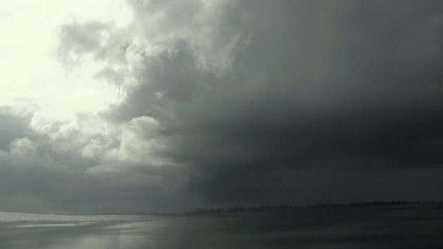 Huge tropical thunderstorm moving in over the ocean as filmed from the water in slowmotion