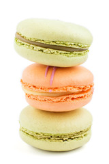 Orange and green macarons or macaroons cakes isolated on white background,  side view.