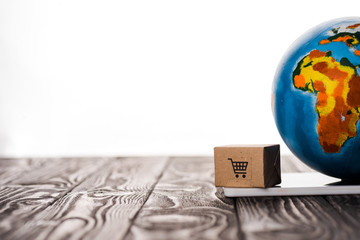 selective focus of toy box and globe on digital tablet isolated on white, e-commerce concept