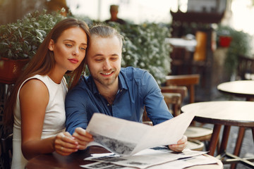 Cute couple in a city. Lady in a white dress. Pair sitting on a cafe
