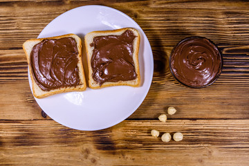 Two sandwiches with chocolate spread on a white plate. Top view