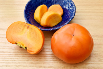 富有柿　Fresh ripe Fuyu persimmons on wooden table.