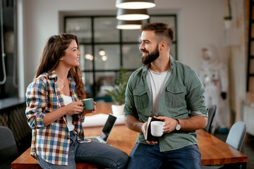 Colleagues in office. Businesswoman and businessman discussing work in office. Two friends in...