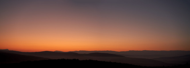 Panoramic view of the predawn twilight. A good view of the low mountain ranges under the transparent morning fog.