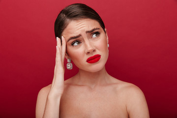 Sad woman with bright red lipstick with headache.