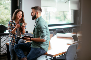 Fototapeta premium Colleagues in office. Businesswoman and businessman discussing work in office. Two friends in working together.