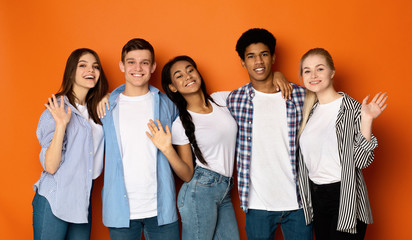 Teen friends saying hello and waving hands to camera © Prostock-studio