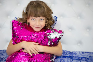Beautiful child girl with a pink pillow