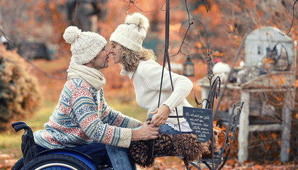 verliebtes Paar mit Rollstuhlfahrer im Garten