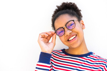 Close up of smiling young mixed race girl with glasses by white wall