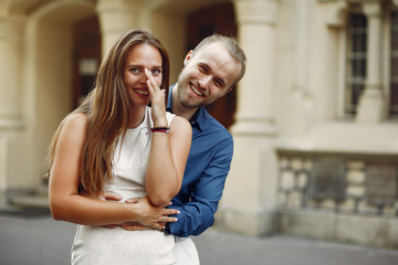 Cute couple in a park. Lady in a white dress. Man in a blue shirt