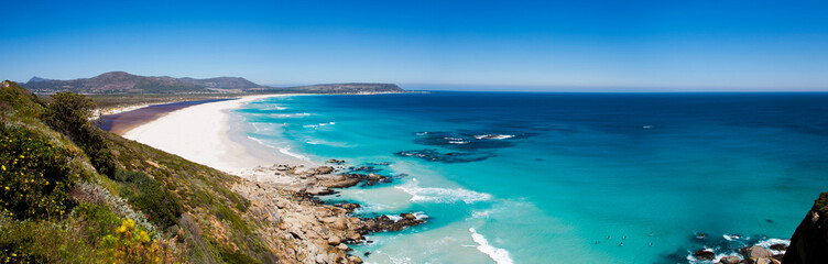 Panoramic of surfers at Noordhoek Beach, Cape Town - obrazy, fototapety, plakaty
