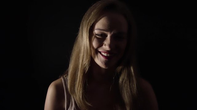Pretty sexy girl smiling and posing into camera in studio,slowmo