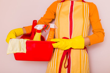 Housewife holding basket with cleaning equipment.