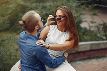 Cute couple in a park. Lady in a white dress. Man in a blue shirt