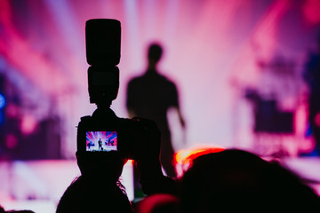 A professional reflex camera with a flash taking photos to a musician in a concert. Live Music....