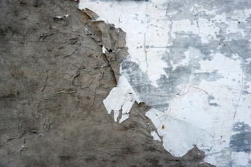 White wall with cracks. Grungy cracked white wall paint peeling off.
