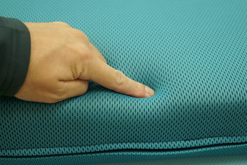 Hand to check the softness of the cushion