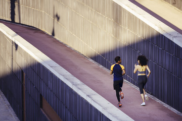 rear view of an interracial couple of runners