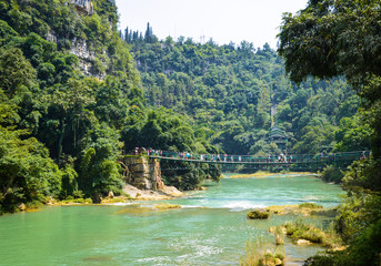 Beautiful scene of forest, river and suspension bridge in China Guizhou Huangguoshu scenery park.