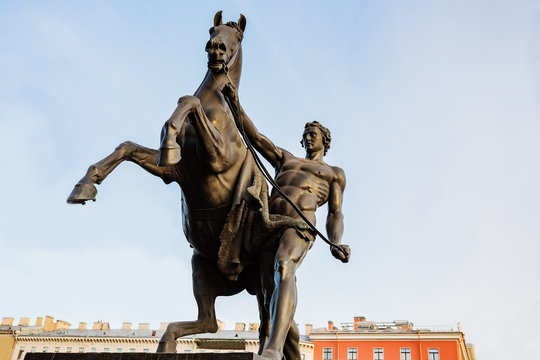 Anichkov Bridge in St. Petersburg with sculptures of horses and a sunny summer morning. Inscription on the bridge: Passage of ships is prohibited.