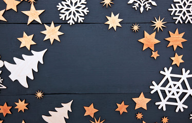 The beautiful christmas background with lots of small wooden decorations on the dark wooden desk.