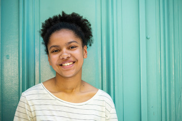 happy smiling young african american girl by green background