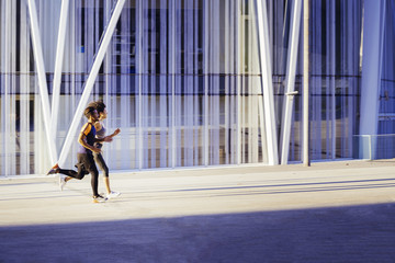 Fototapeta premium interracial couple running fast in the city street