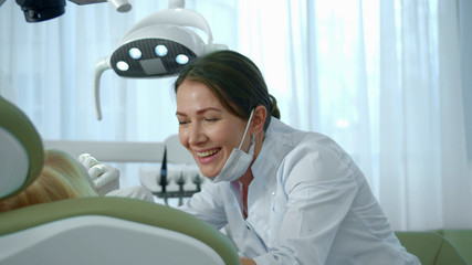 Naklejka premium Doctor looked at the girls teeth and continued to speak with her.