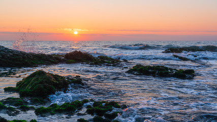 Colorful sunrise on a rocky seashore