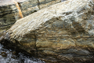 The rocks with beautiful patterns set in the river flowing through.