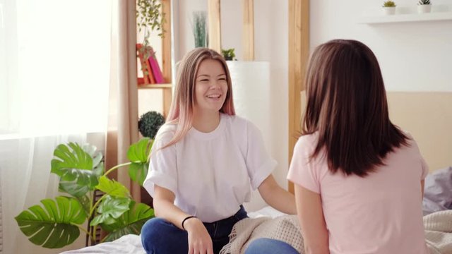 Female friendship. Weekend leisure. Two cheerful girls having fun conversation at home.