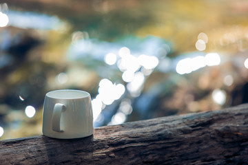 White coffee mugs on the rocks against a beautiful waterfall background, Coffee with nature, waterfalls,