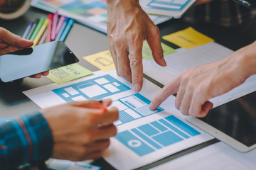 The web designer team is helping to design applications for mobile phones. UX UI designer concept