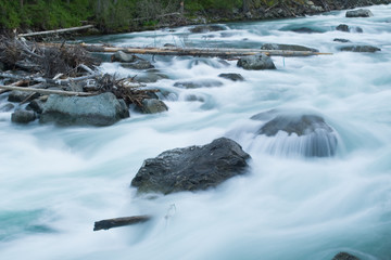 Huge stones in the bed of a mountain river are streamlined by a swift stream of water. Photographed...