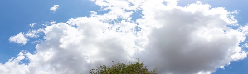 Beautiful blue clear sky with white clouds background in sunny day and copy space. Nature bright sky background image. Summer blue sky with sunlight. Texture for Design. Natural cloudy Wallpaper.